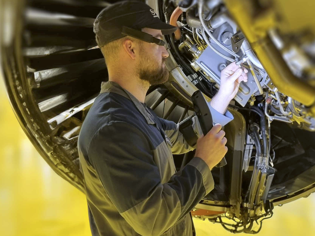 A manual operator using aRdent to work on an aircraft engine